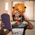 a man with a mask holding a skateboard